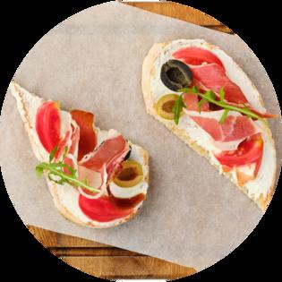 Bruschetta with prosciutto, olives and tomatoes
